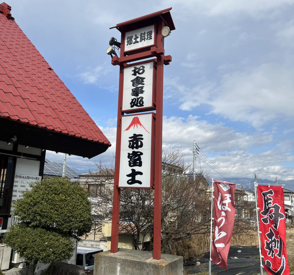 赤い屋根の近くに赤富士の看板と旗